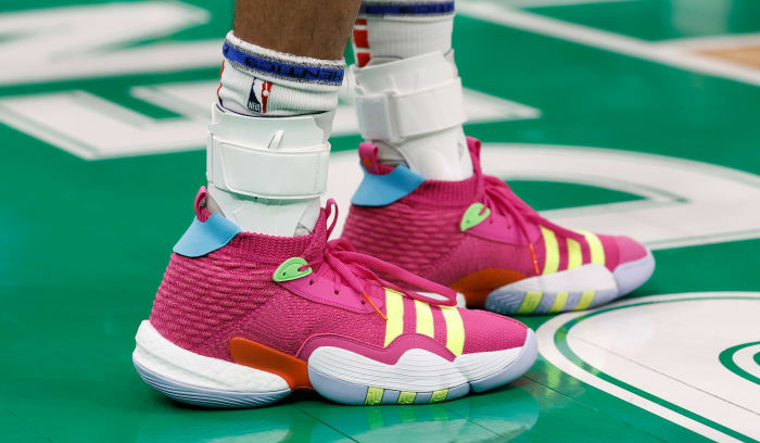 View of Trae Young's pink and yellow adidas shoes.